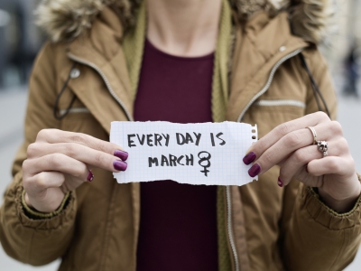 A woman holds a paper that reads 