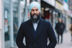 Jagmeet Singh stands outdoors and smiles at the camera