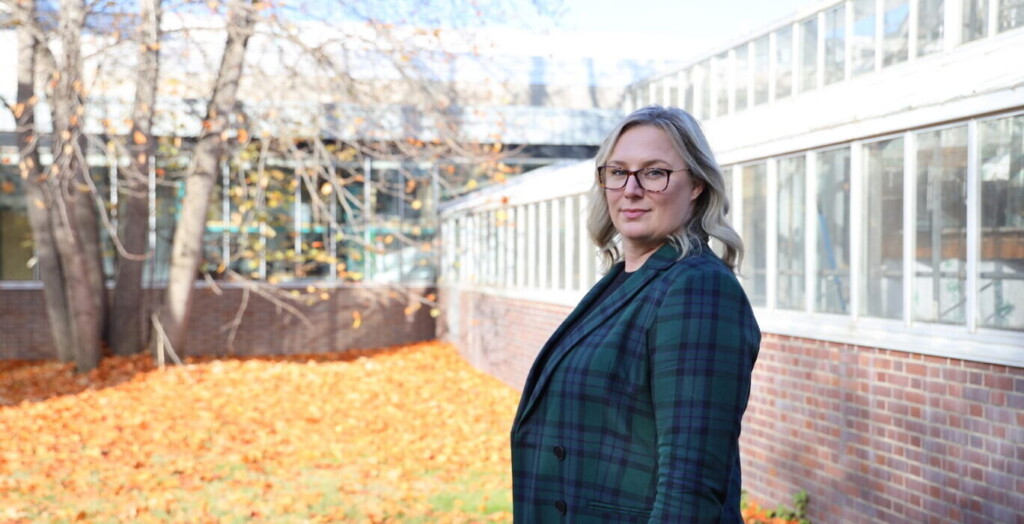 Jessica Davis stands to the side in front of a building.