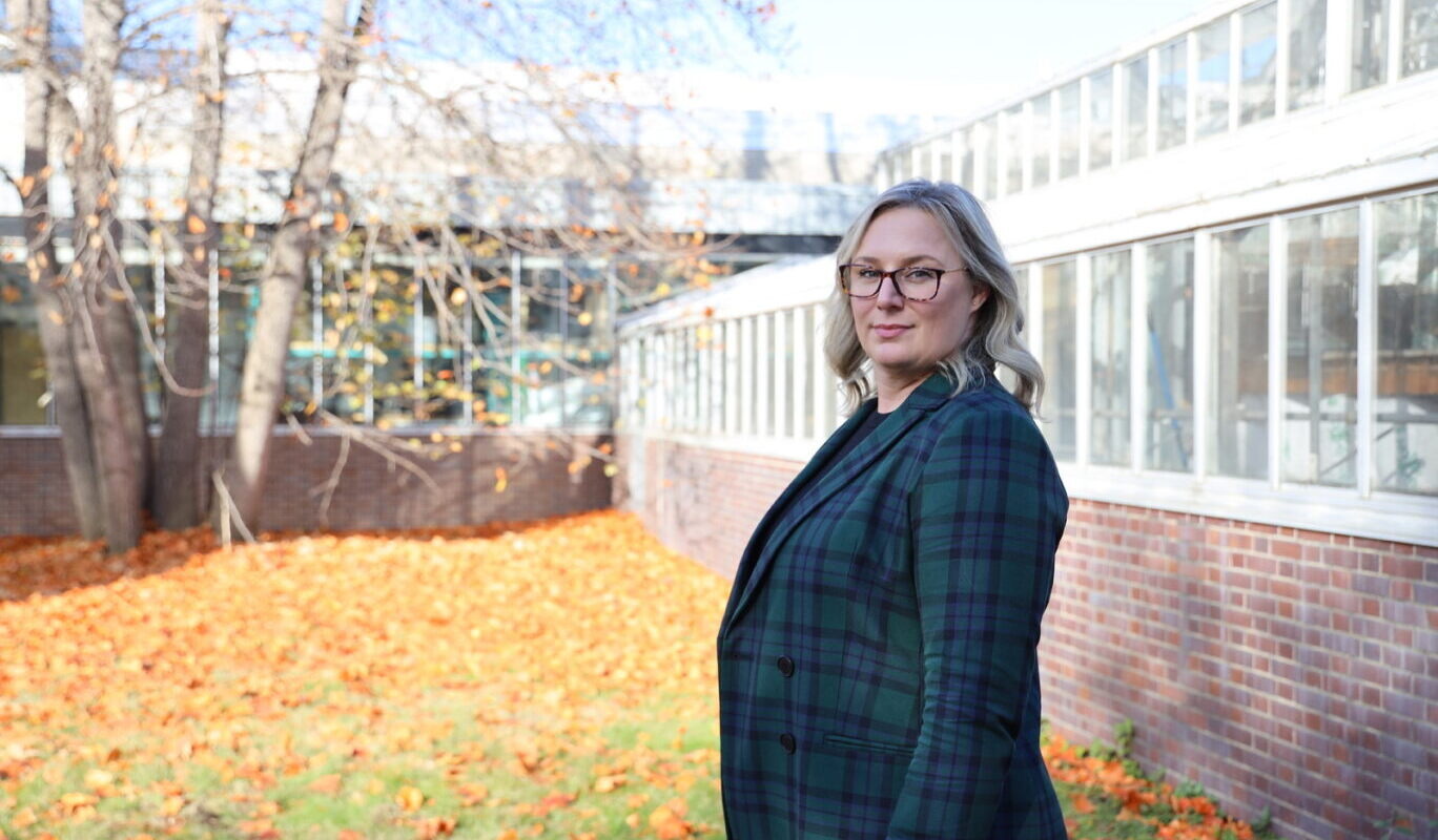 Jessica Davis stands to the side in front of a building.