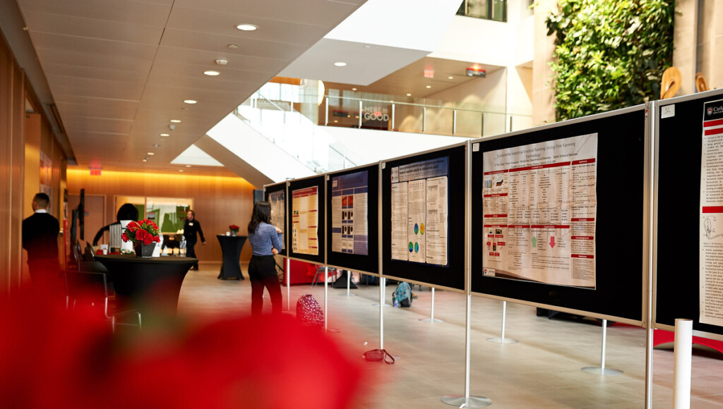 An attendee examines a poster in Richcraft Hall during Life Sciences Day.