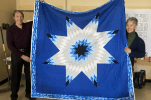 Adjunct Professor Lyette Fortin displays the blanket she received during her design studio class.