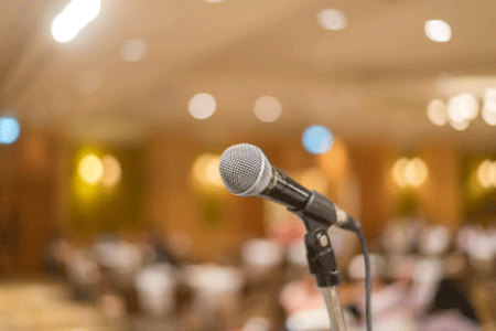 A photo of a microphone, a reception room in in the background.