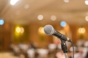 A microphone is pictured in front of a lecture hall.