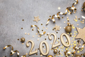 New Year decorations lie on a grey background surrounding the number 2020.