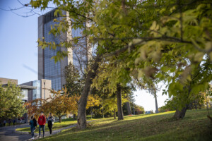 Three students walking through a university campus