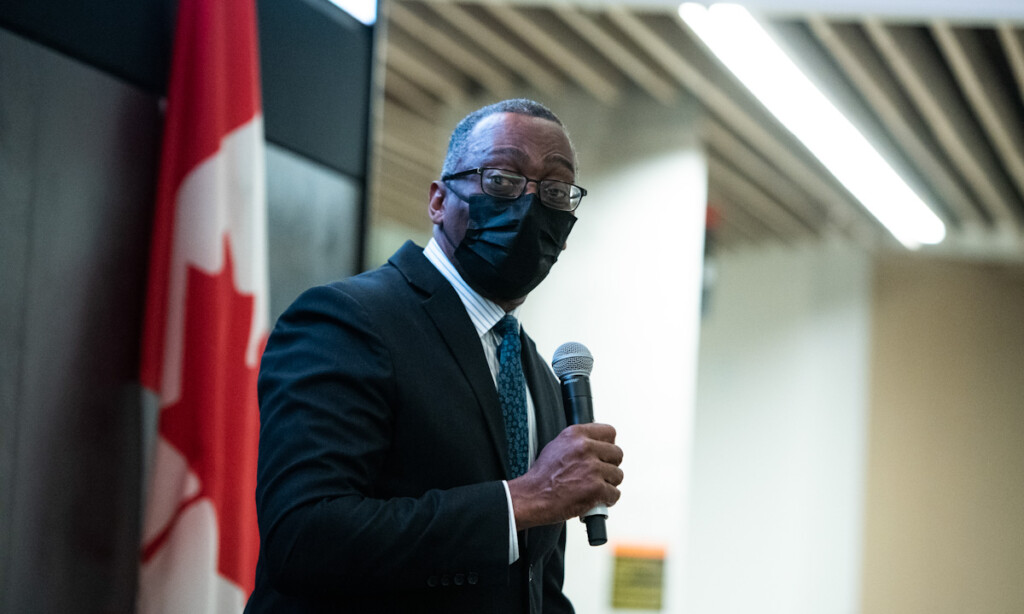 Professor Gerald Grant speaks while holding a microphone.