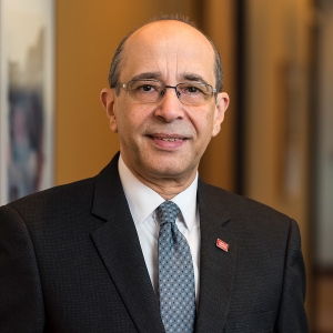 Headshot of a professionally dressed man with glasses