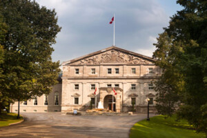 A photo of Rideau Hall situated between two trees.