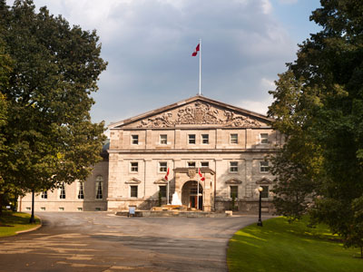 A photo of Rideau Hall situated between two trees.