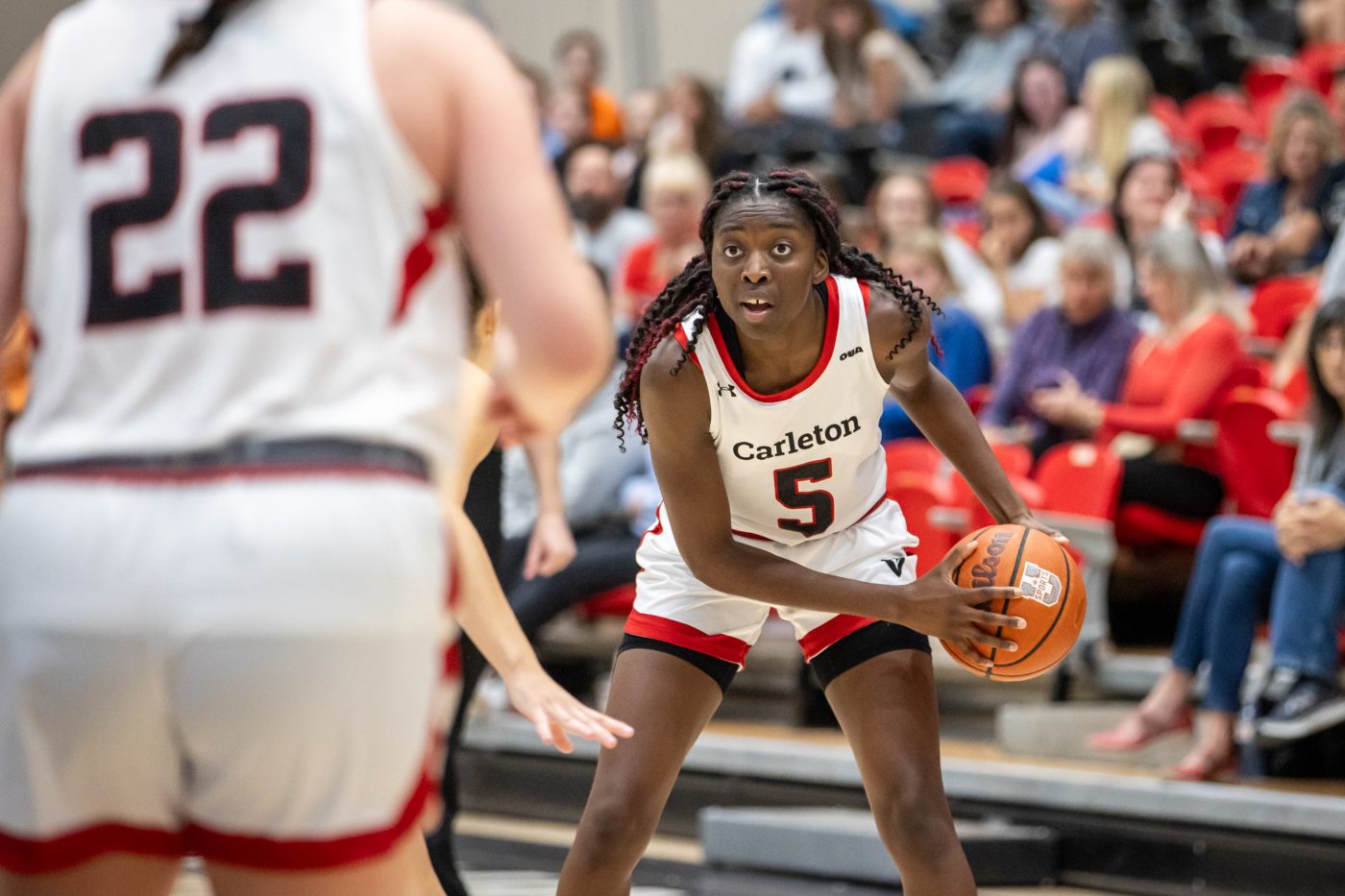 Close up of Black woman with basketball preparing to pass to team mate.