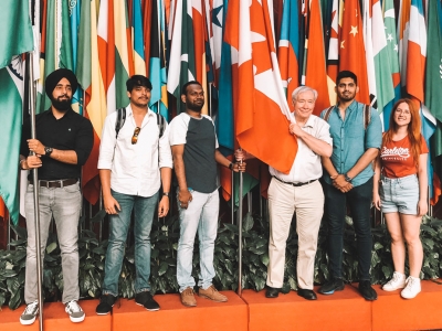 Carleton student stand with numerous flags from countries around the world.
