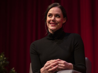 Tessa Virtue smiles at the audience from the stage.