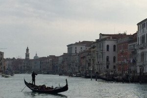 A gondolier guides his boat through a canal in Venice.