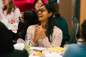 A conference attendees laughs as she listens to speakers.