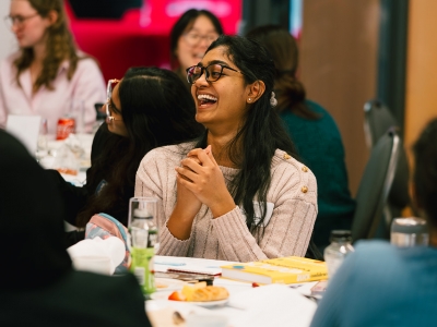 A conference attendees laughs as she listens to speakers.