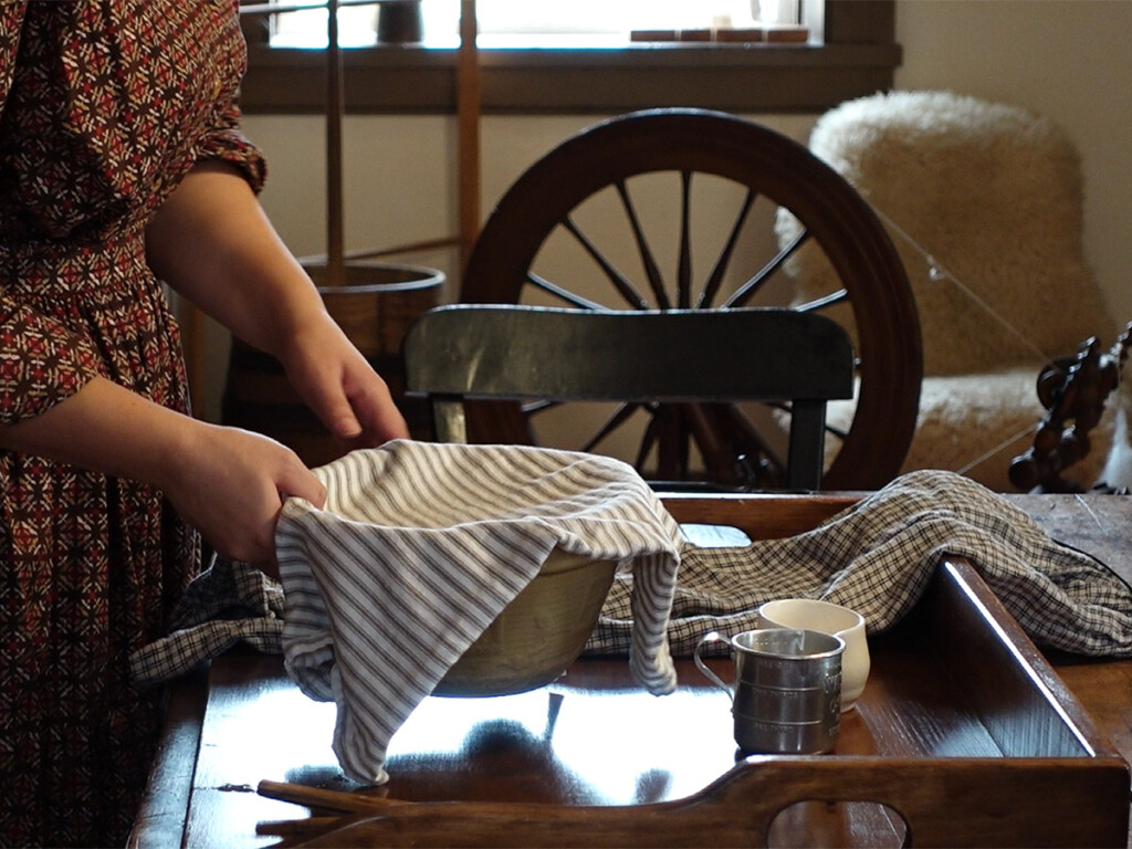 Preparing corn meal sourdough pancakes in the Fitzpatrick Kitchen (c. 1840) at Lang Pioneer Village Museum, preserving Canadian culinary history.
