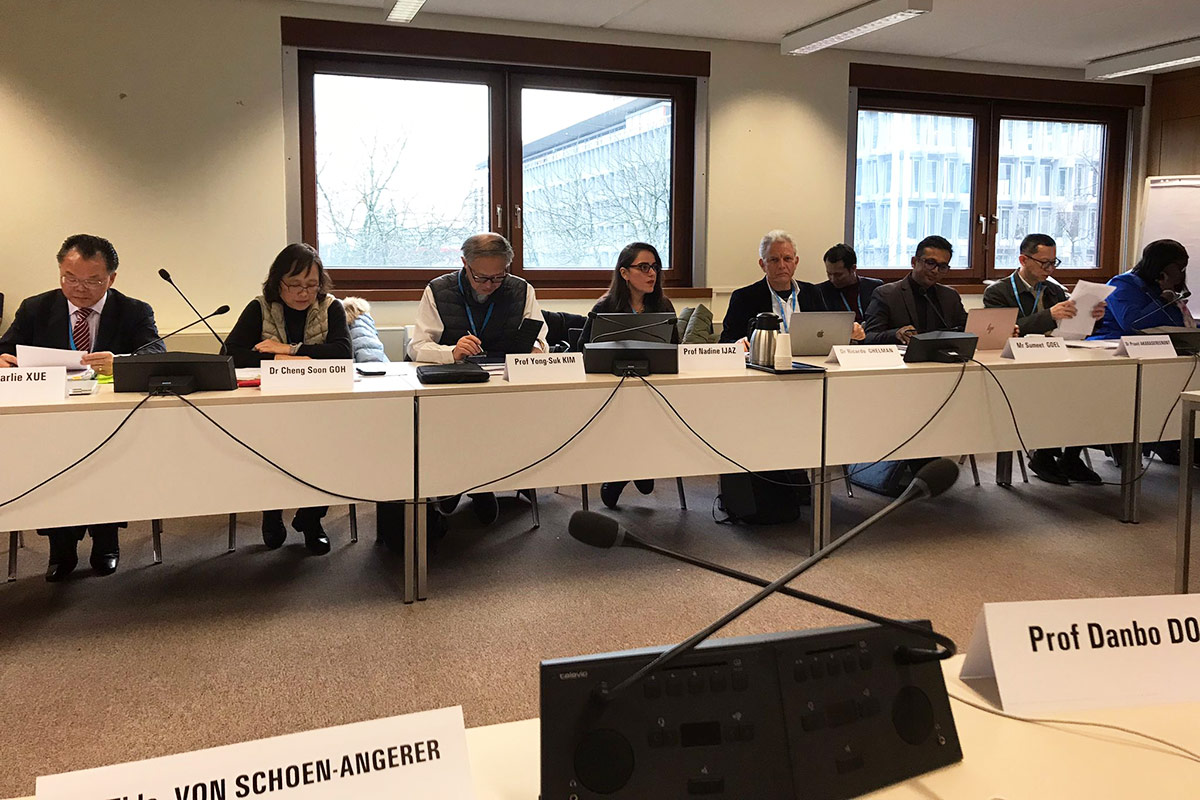 People sitting around a large table inside an office boardroom.