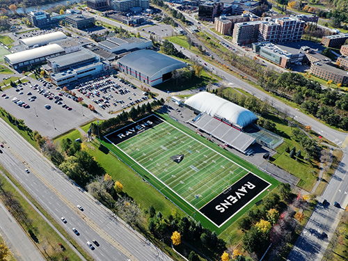 An aerial shot of the Carleton University campus. The football field can be seen with the word Ravens in the end zone.