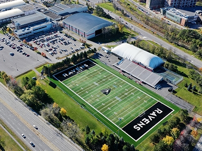 An aerial shot of the Carleton University campus. The football field can be seen with the word Ravens in the end zone.