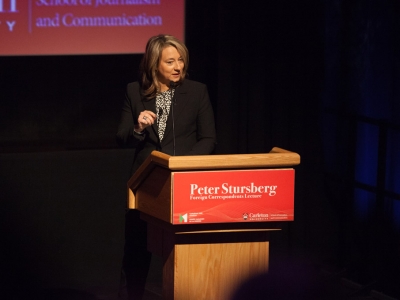 Adrienne Arsenault speaks at a podium.