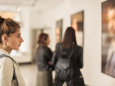 A group of women look at art in a gallery.
