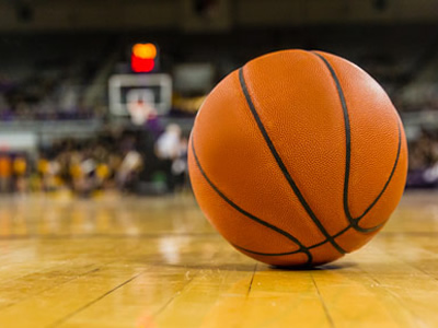 A basketball sits on a court.