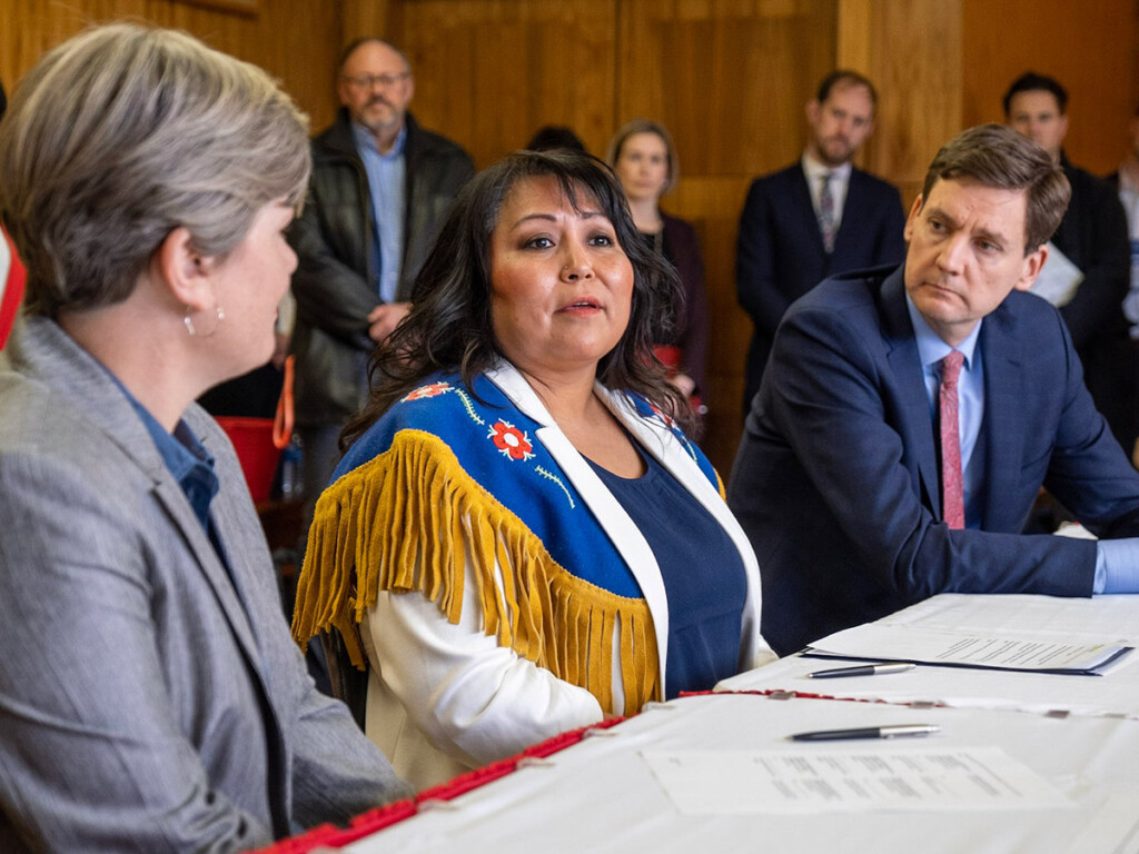 Three people sitting at a table during a meeting