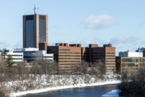 Carleton campus is seen in winter with snow on the banks of the river.