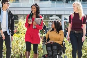 Group of Carleton University walking on campus; the student in the middle is using a wheelchair.
