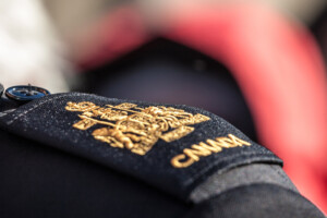 Picture of a closeup on a shoulder pad of a Canadian service an with the official coat of arms of Canada
