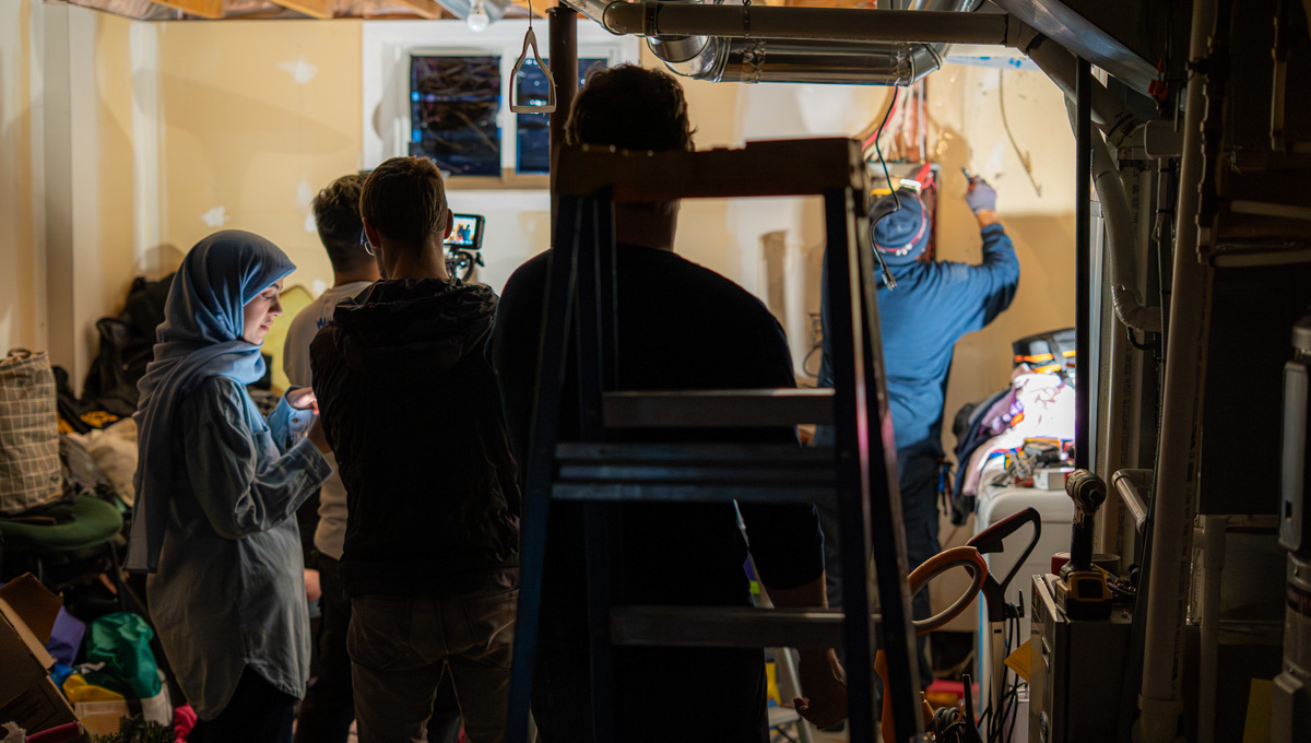 Researchers look on as energy efficiency technology is installed in a residential home..