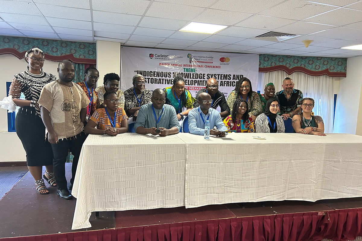A large group of people surrounding a long table.
