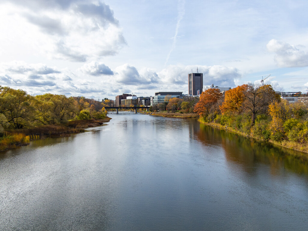 A photo of the Carleton University campus, taken from the other side of the Rideau River. Dunton Tower is visible in the distance.