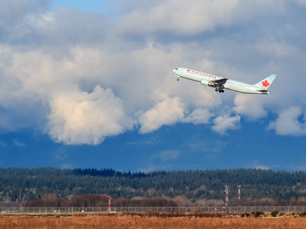 A distant view of an Air Canada flight taking off from an airport.