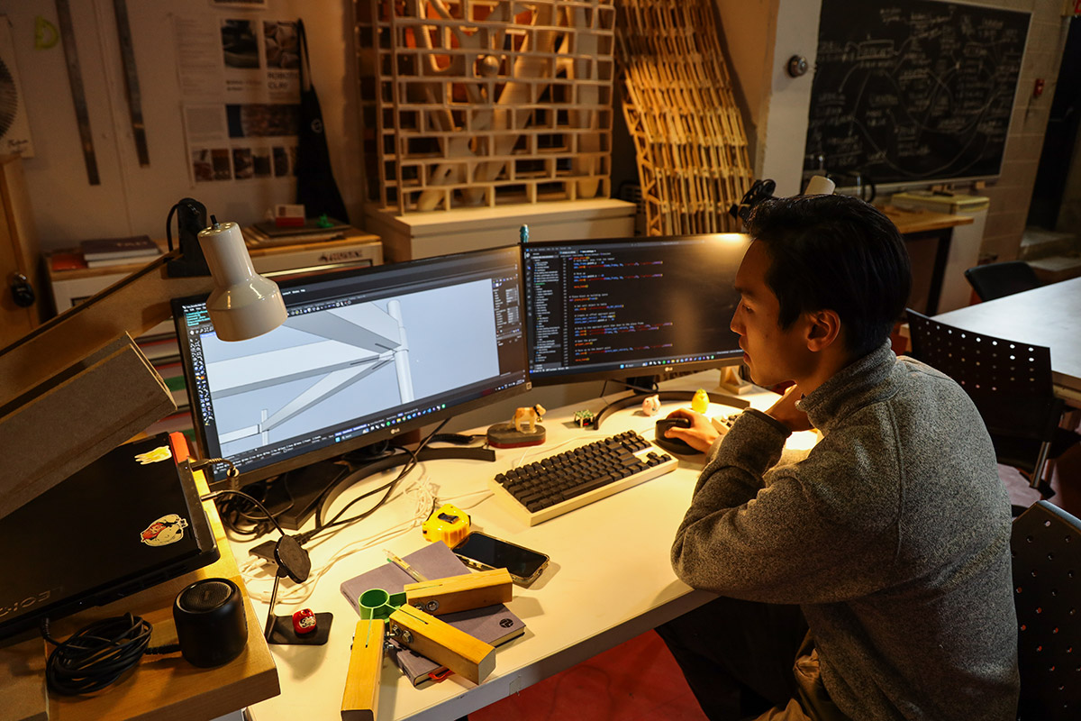 An over the shoulder view of a man working on a computer.