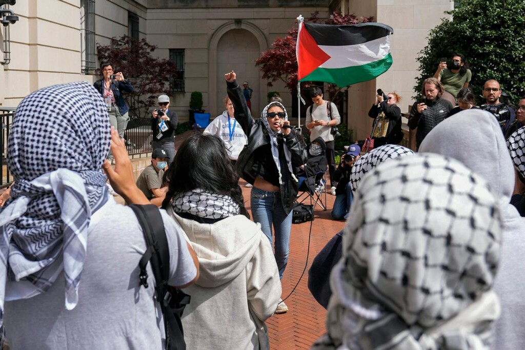 A protestor speaks into a microphone at a rally.