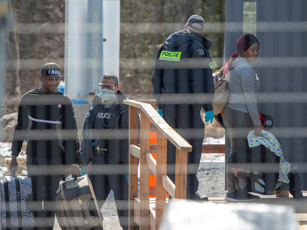 Asylum seekers cross the border from New York into Canada on March 18 at Hemmingford, Que., two days before Canada said it would now send those seeking asylum back to the U.S. (THE CANADIAN PRESS/Ryan Remiorz)
