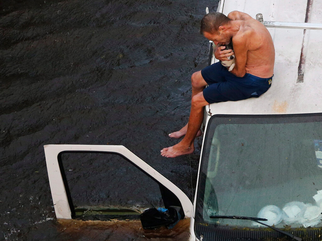 A man tries to get his dog out of a flooded neighbourhood in Lumberton, N.C., in September 2018 in the aftermath of hurricane Florence. (AP Photo/Gerry Broome)