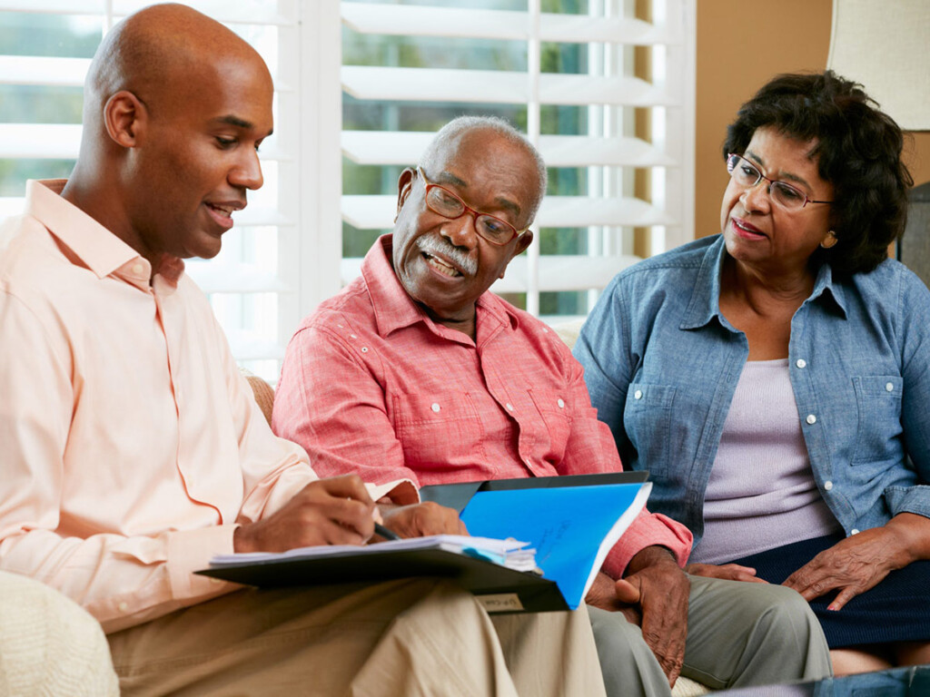 An elder couple discuss savings with a financial advisor.