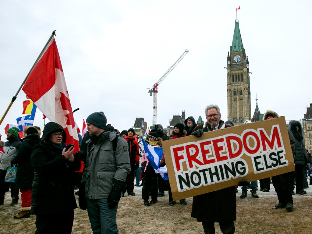 A man holds a sign on Parliament Hill to support trucks lined up in protest of COVID-19 vaccine mandates and restrictions. (Photo: AP Photo/Ted Shaffrey)