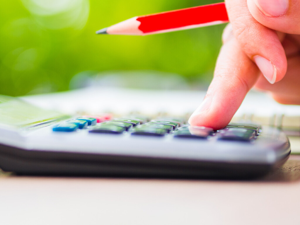 A finger presses a button on a calculator (Shutterstock)