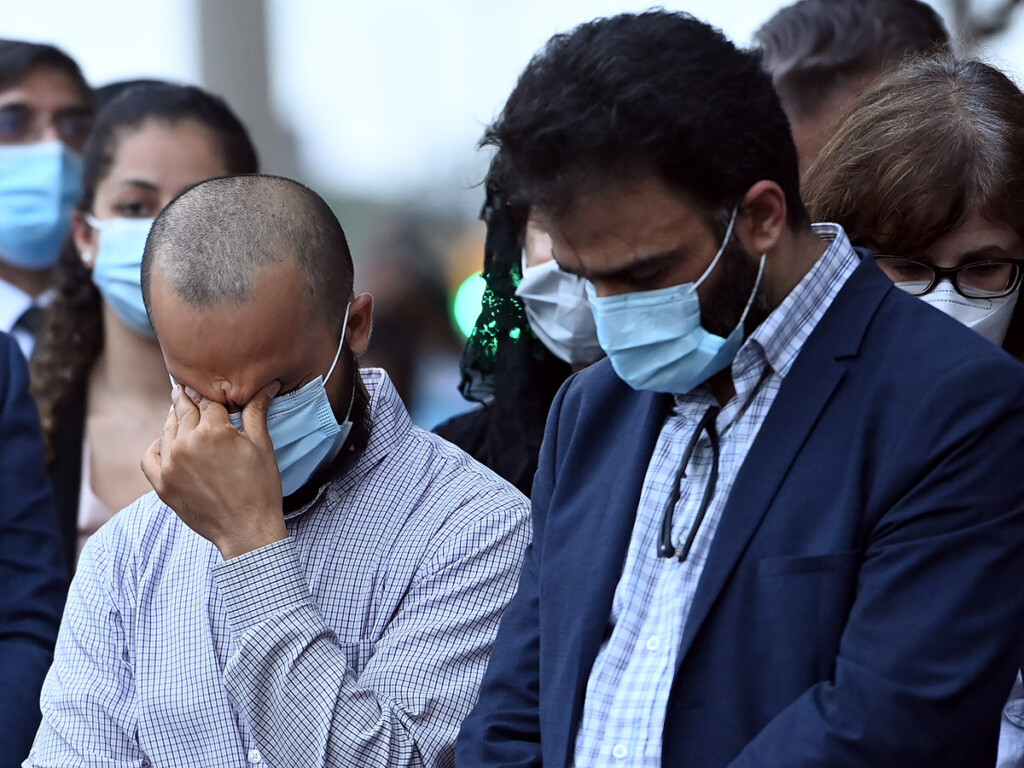 Mourners react during a moment of silence at a vigil for the victims of the deadly vehicle attack on a Muslim family in London, Ont. (THE CANADIAN PRESS/Nathan Denette)