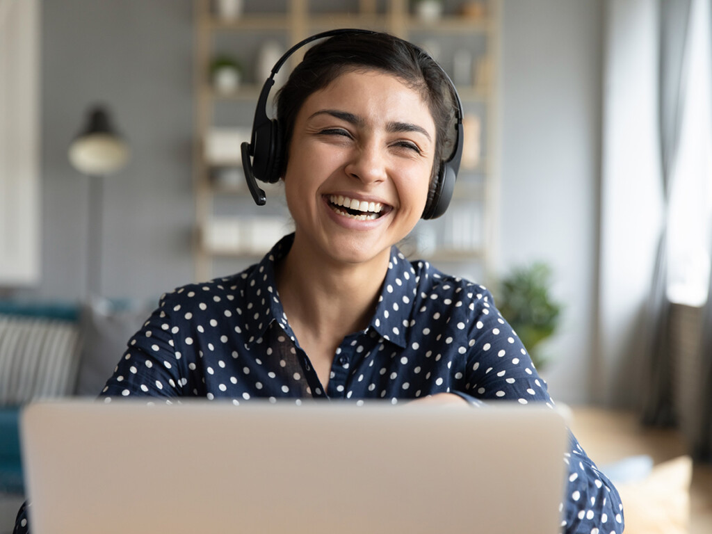 A woman wearing a headset laughing (Shutterstock)