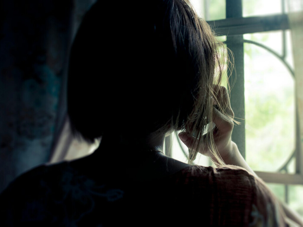 An over the shoulder view of what appears to be a woman making a phone call.