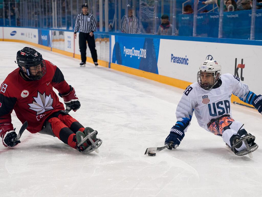 Billy Bridges of Canada and Kevin McKee of the U.S. in action during the para ice hockey gold medal game at the Paralympic Winter Games in Pyeongchang. (Bob Martin/Olympic Information Service), CC BY