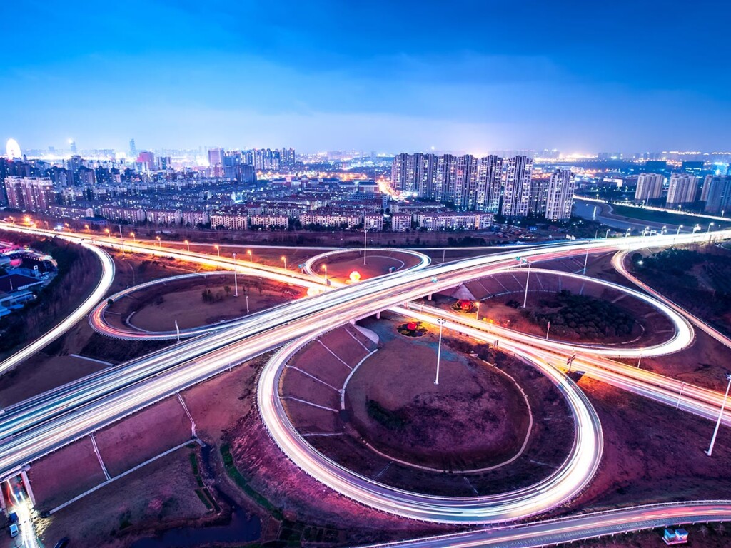 A highway with a city skyline in the background.