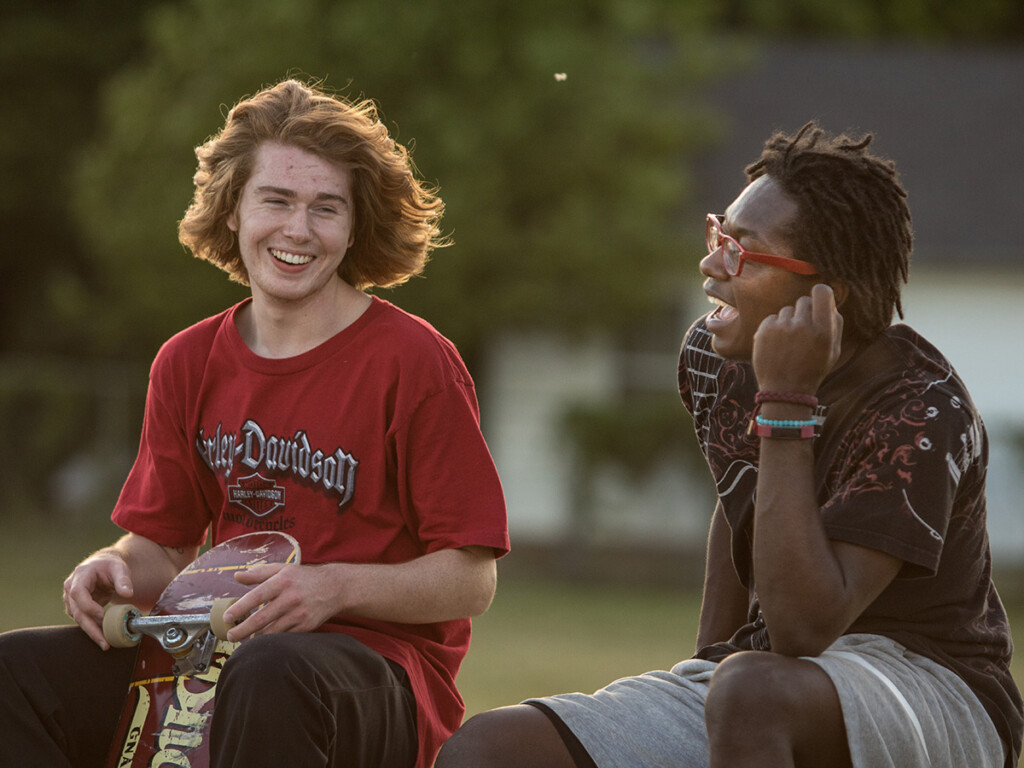Two teenage boys laugh in conversation