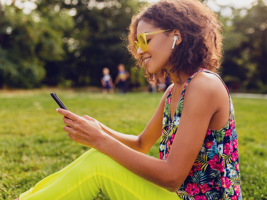 A woman listens to music on her mobile phone