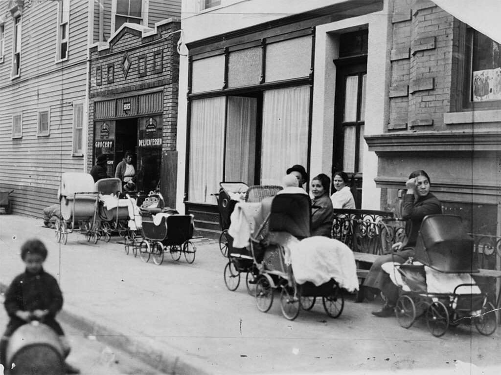Women and men sitting with baby carriages in 1916 in front of The Sanger Clinic in Brooklyn, considered the first Planned Parenthood clinic.